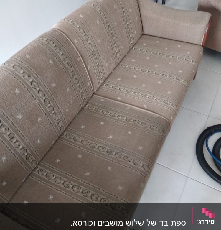 ספה חומה עם דוגמה, צינור ניקוי על הרצפה